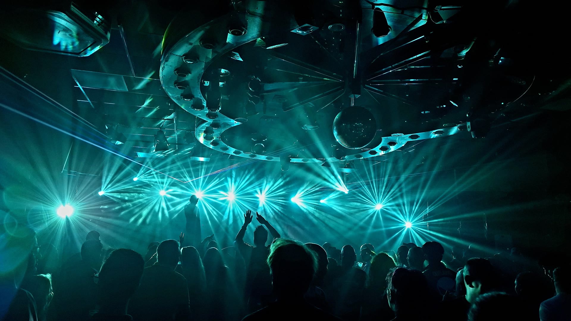 Blauwgroene lichtstralen boven een volle zaal