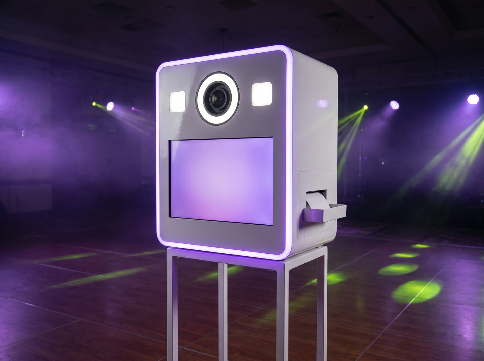 Een witte fotobooth met paarse ledrand, ringlamp en touchscreen in een zaal met paars licht