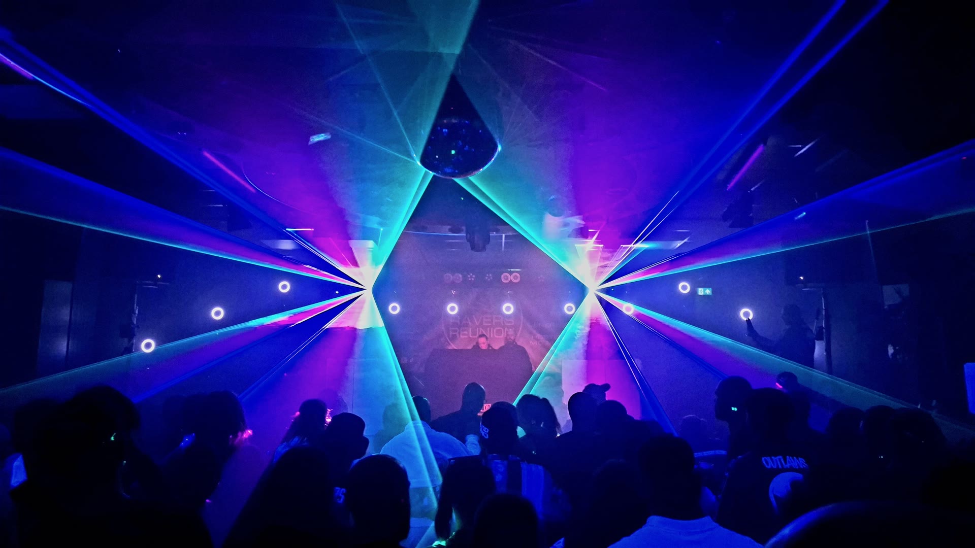 Blauwe en paarse lasers en lichtstralen boven een publiek